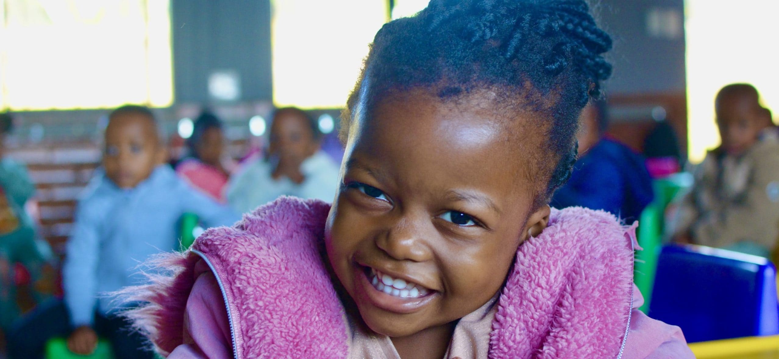 Happy girl smiling in classroom setting.