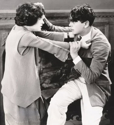 Vintage scene of a woman and a young man in a tense confrontation.