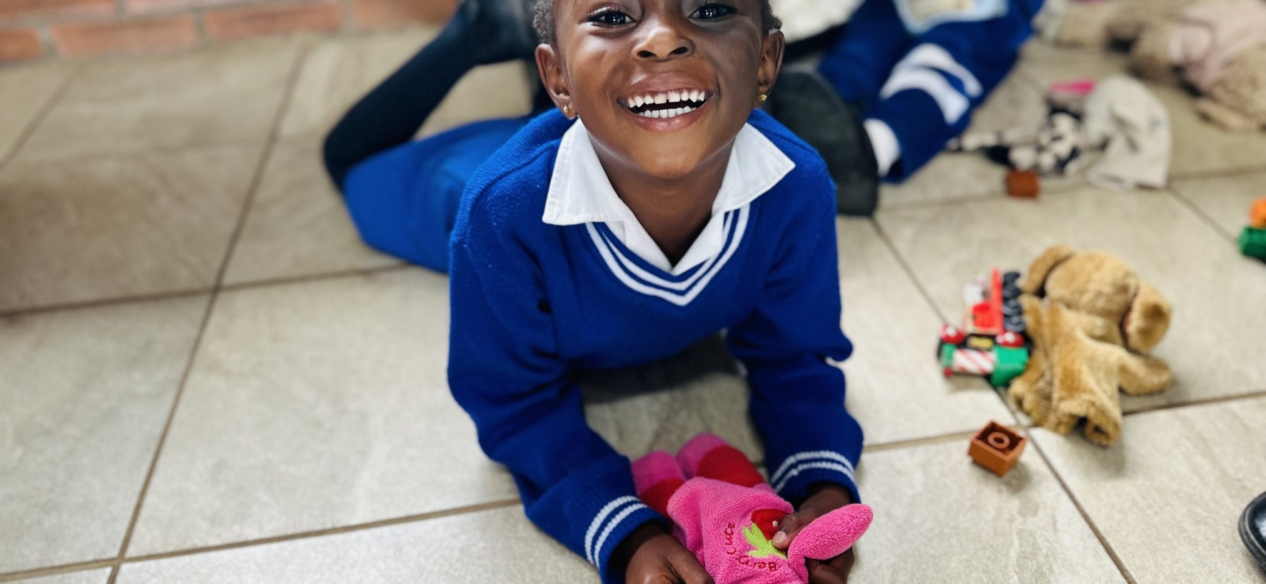 Happy child playing with toys on floor.