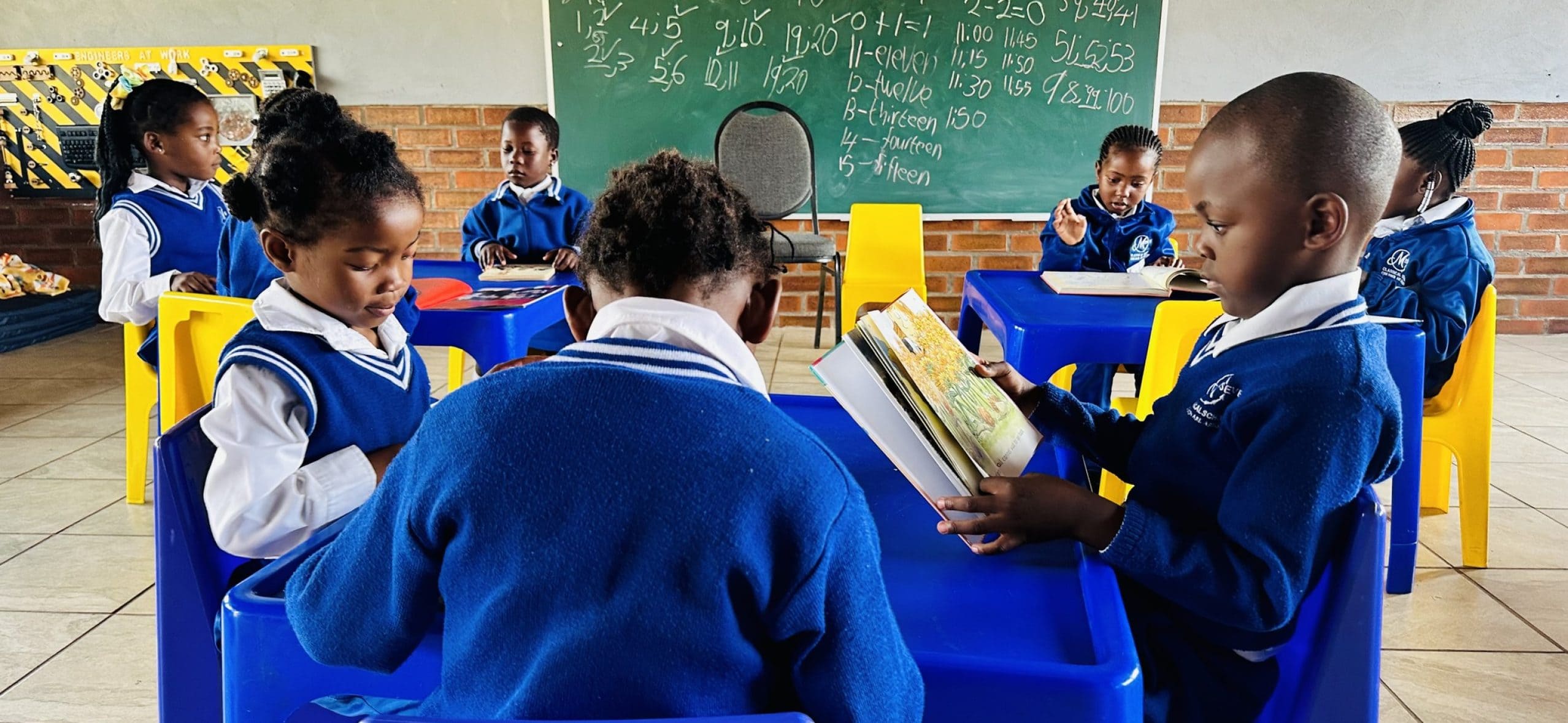 Students studying in classroom with blue uniforms.