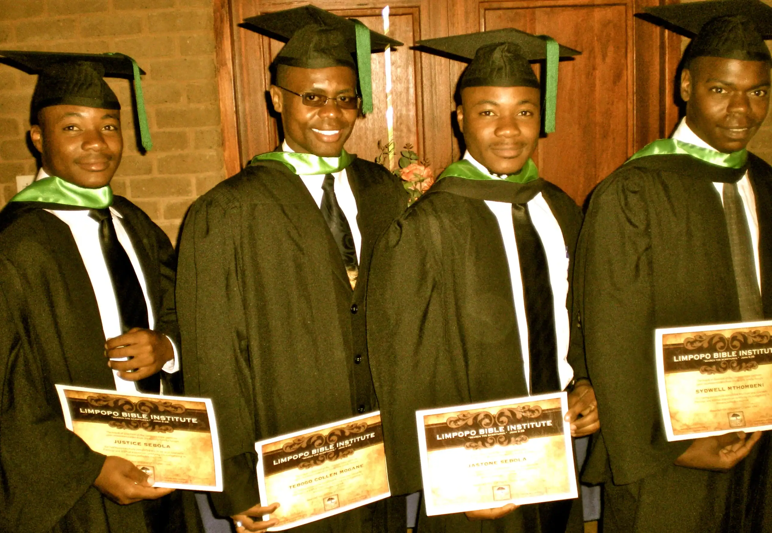 Graduates in caps and gowns holding diplomas at Limpopo Bible Institute.
