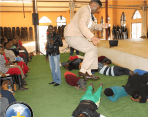 Preacher addressing congregation during service in African church.