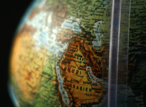 Close-up of Middle Eastern countries on a globe with a magnifying glass.