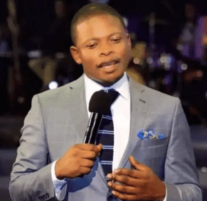 Preacher delivering a sermon at a religious gathering with a microphone.