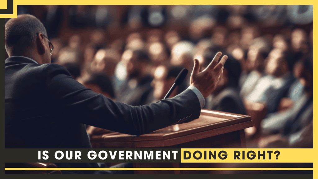 Speaker at podium addressing a large audience about government actions.
