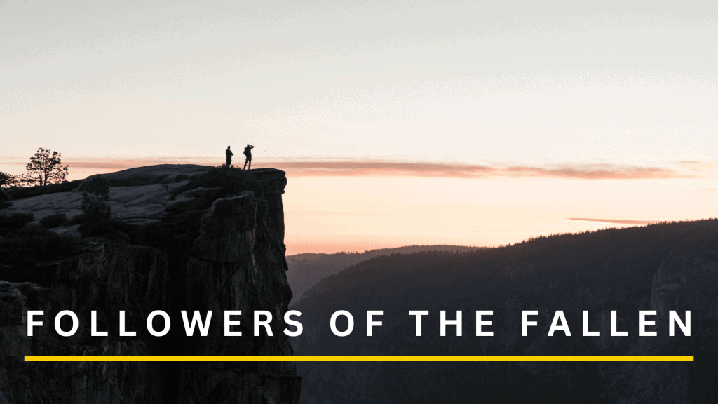 Two hikers standing on a cliff edge at sunset with scenic mountain views.